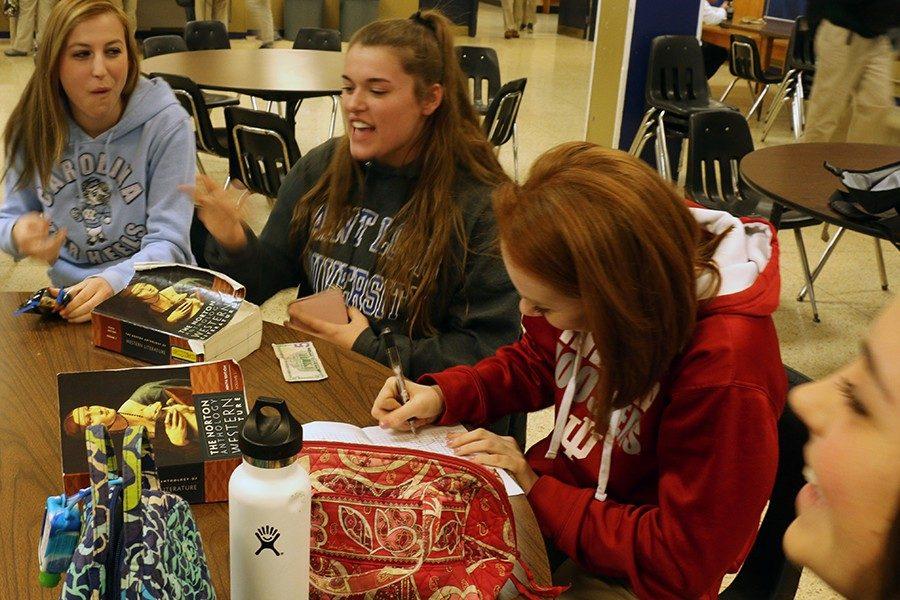 Seniors Lauren Buday, Morgan Klase and Kaylyn Krauss eat lunch and work on homework during G period on Feb. 2. 