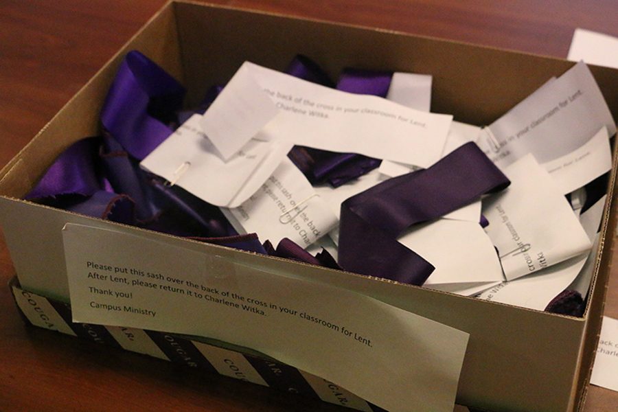 In the first floor Kelly Hall teacher's workroom, a box of purple ribbons is available for teachers to add to their classroom crucifixes. 