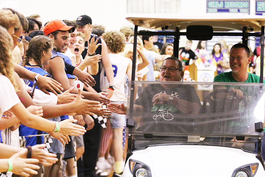 With theology teacher Mr. Marc Behringer '84 as his driver, Fr. John Zahn takes a lap around the Welch Activity Center gym floor at last spring's Irish 500. Fr. Zahn passed away over the weekend of Aug. 26-27. 