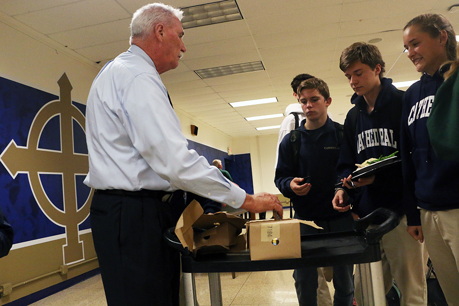 During lunch on Sept. 13 in the cafeteria. Dr. Tom Greer, chief officer for student affairs, hands out ice cream bars as part of the school's 99th birthday celebration. 