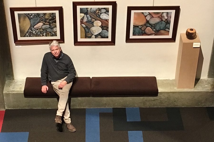 Art teacher Mr. Jon Kane poses in front of several of his pieces that are part of an exhibition at Clowes Hall on the Butler University campus. 