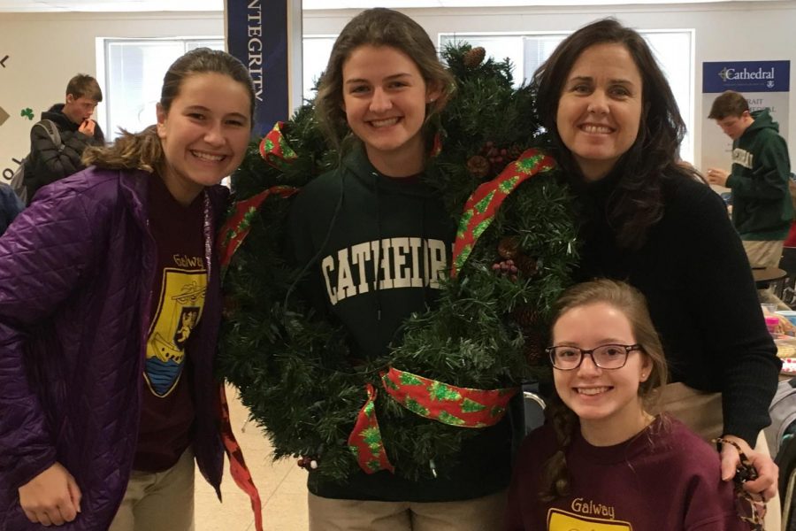 Sophomores Emily Veigel, Kaylor Jasiak, Natalie Schorr and English teacher Mrs. Sue Welch display a Christmas wreath during their Bodkin town meeting Dec. 11. 