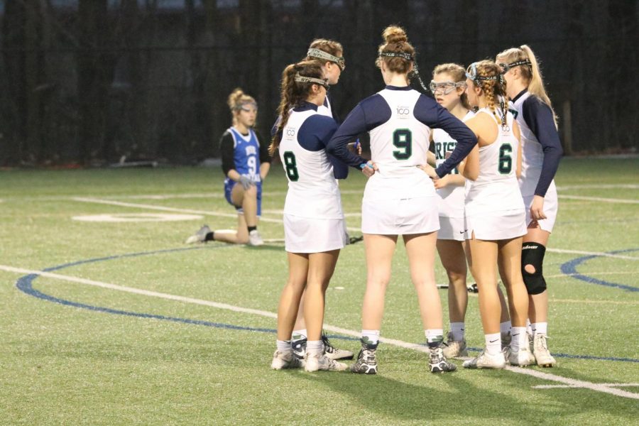Member of the womens lacrosse team discuss strategy at a recent game. 