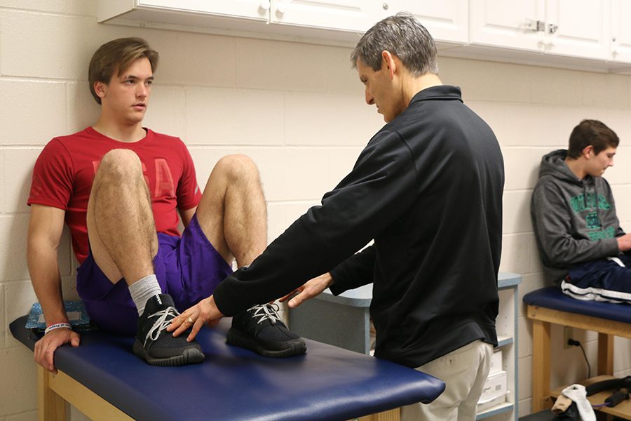 Athletic trainer Mr. Mike Hunker, assisting junior John Leffel, will return for campus next year, along with health professionals from the Community network. 
