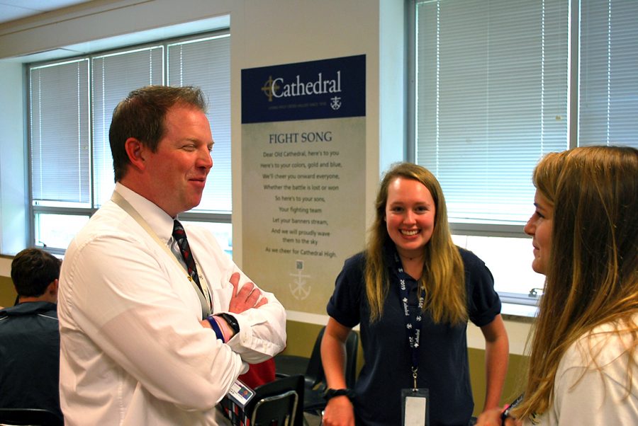 Mr. Jere Kubuske talks to seniors Ava Beloat and Katherine Gallagher during lunch in the cafeteria. 