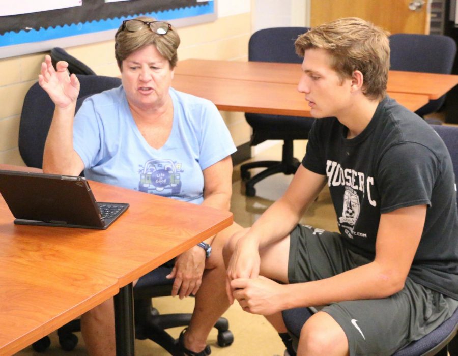 English teacher Ms. Laurie O’Brien assists senior Nick Kolosso with his college essay at the college application boot camp last August. The camp alowed seniors to get a head start on their college applications and essay writing. English teachers were available to give advice regarding their college essays. 