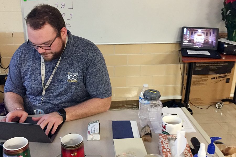 Theology teacher Mr. Matt Cannaday works as his desk in his classroom in Kelly Hall. 