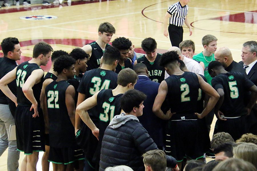 The men's basketball team gathers around the coaching staff during the Dec. 1 game against Brebeuf Jesuit. 