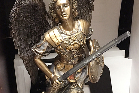 A statue of the archangel Michael, who guards heaven, stands on the desk of School Resource Officer Tabetha Emenaker. 
