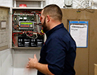 As part of his daily routine, director of maintenance Mr. Carl Grill checks the electrical box in the Kelly Hall basement. 