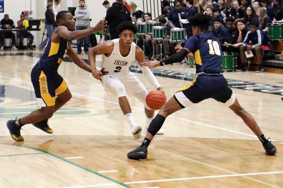 Senior Armann Franklin drives down the court between two South Bend Riley defenders during a game earlier this season in the Welch Activity Center. Franklin and his teammates will open Sectional play on Feb. 26 against Lawrence North.