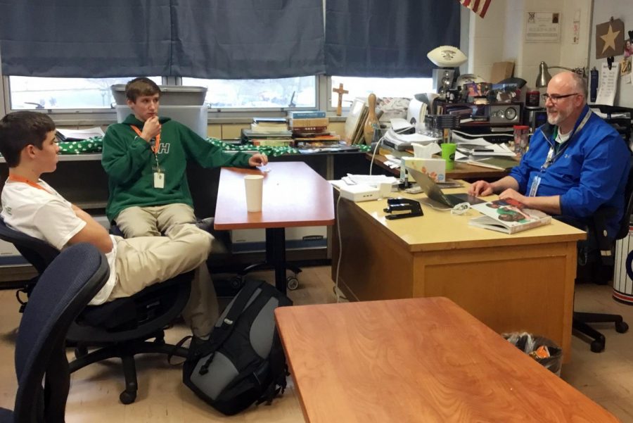 In his classroom on March 29, social studies teacher Mr. Anthony Ernst talks to sophomores Isaac Michael and Levi Wojtalik. 