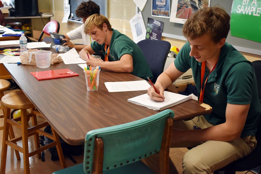 Junior Jake Kazan, far right, takes notes during Mr. Howard Fogel's E period chemistry class. 