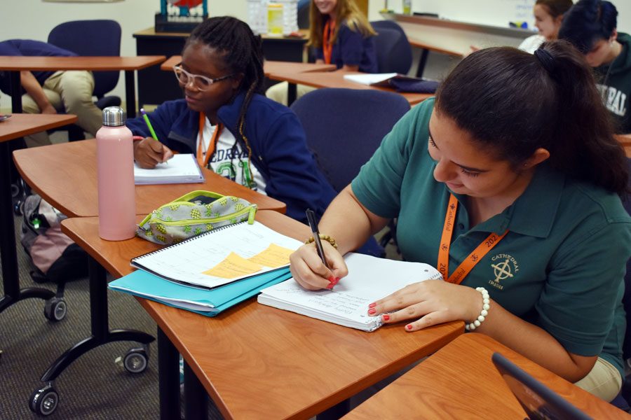 Ana Arce-Rameriz, right, takes notes during her E period English class in Loretto Hall. 