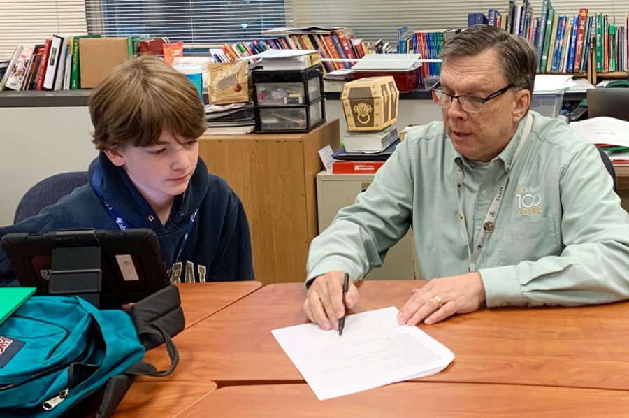 In his classroom, Mr. Gary Spurgin assists a student with an assignment. 