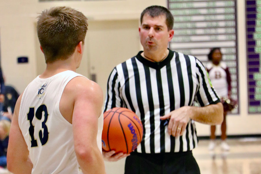 During the men's varsity basketball game on Dec. 7 against Brebeuf Jesuit, an official prepares to hand the ball to senior Ryan Trusler. 