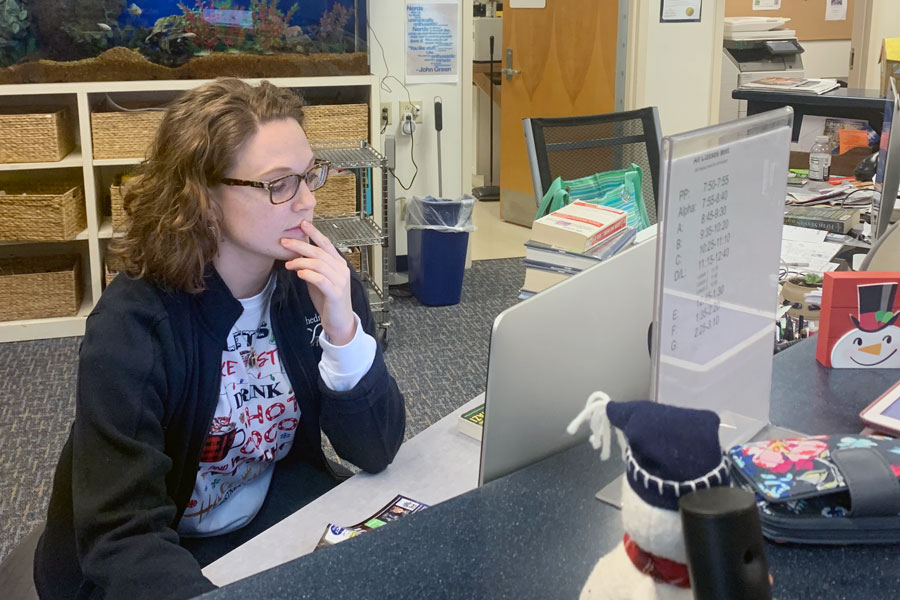 Library/media assistant Ms. Alannah Cataldo works at her desk. She provided information for how students could access books and other materials during eLearning. 