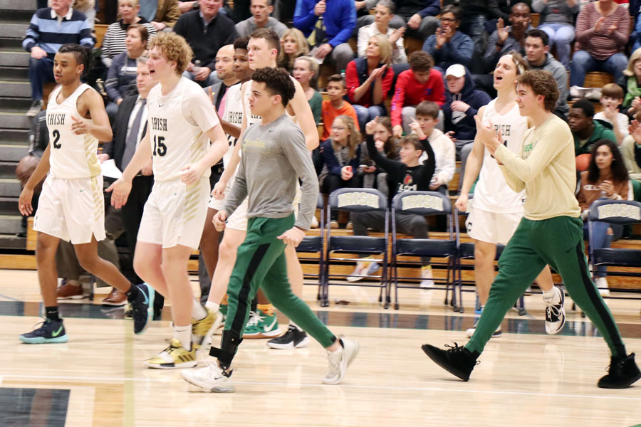 Junior Camden Jordan, wearing a gray long-sleeved T-shirt, and his teammates celebrate a 60-55 win over Roncalli on Jan. 10. 