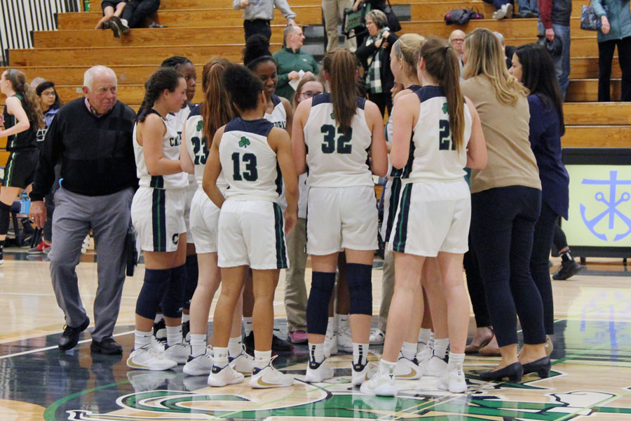 The women's basketball team gathers around its coaches during the varsity game in December against Zionsville. 