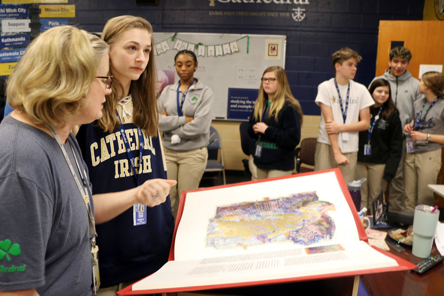 Theology teacher Mrs. Cece Kasberg 83 and her students view a specially printed St. Johns Bible in her classroom. 