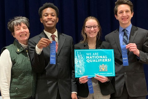 Speech and debate Head Coach Mrs. Jeanne Malone stands with three of the four qualifiers for Nationals: Victory Sampson, Lauren Dubbink and Nick Grill. Madison Ackley is not pictured. 