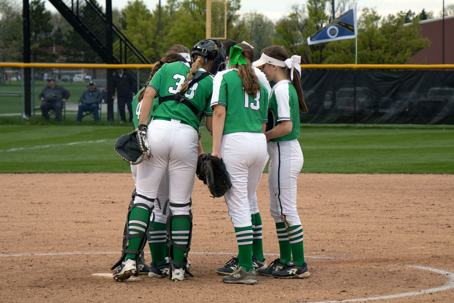 Grace Lorsung and her fellow softball team members gather on the mound during a varsity game last season. 