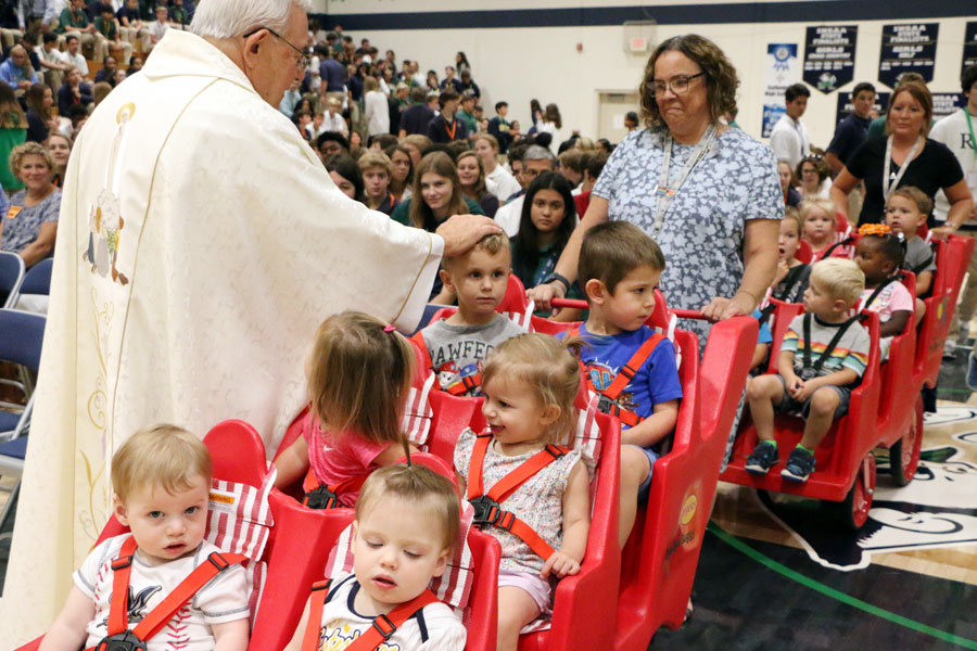 Fr. Jeff Godecker greets children from Irish Blessings at a Mass at the beginning of the school year. 