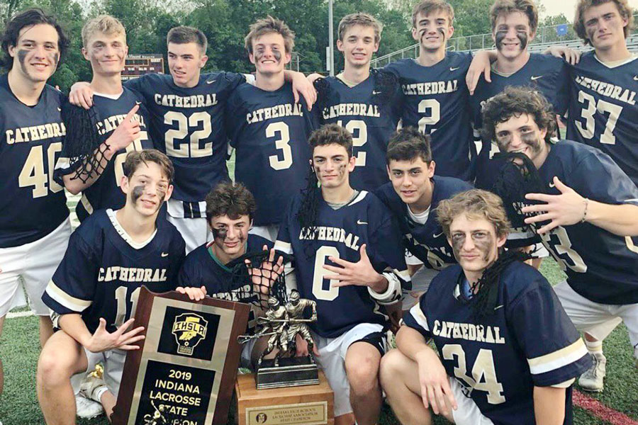 The men's lacrosse team poses with the 2019 State championship trophy. 