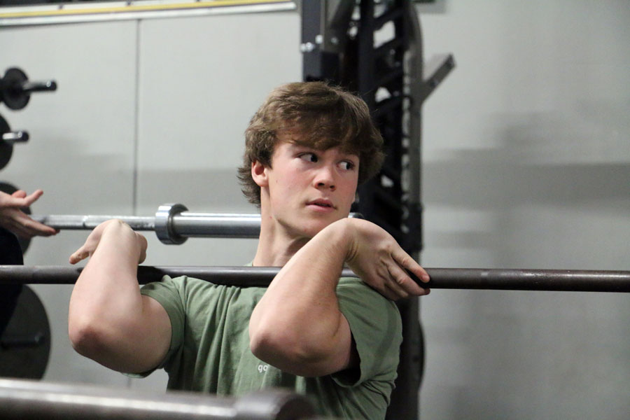 Senior Cameron Clark lifts weights at school before the shutdown of the campus. 