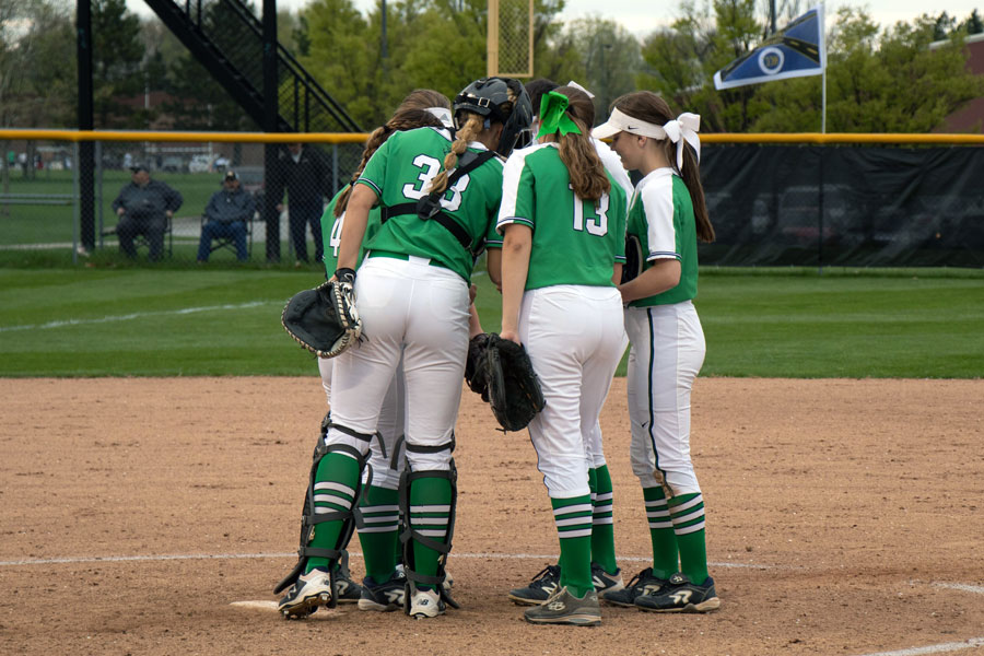 In her catcher's gear, senior Grace Lorsung meets with her teammates during a regular season game last year. 