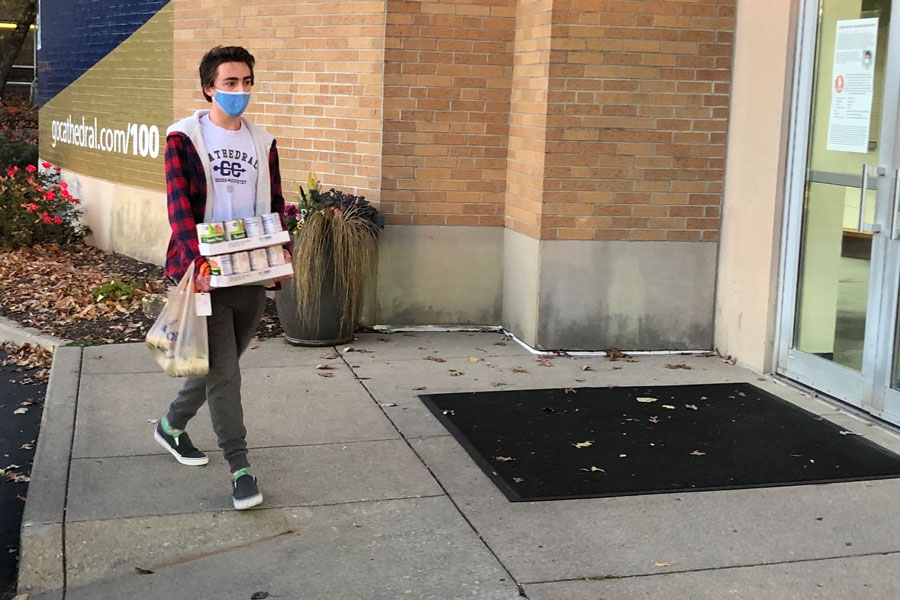 Senior Jack Larch drops off his canned food donation before school on Nov. 6. Donations to the annual food drive also were made available to students at the on-campus food pantry. 