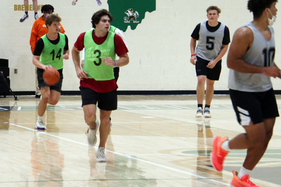 Senior Nathan McCahill (14) brings the ball up the court during the intramural basketball championship game on April 7 in the Welch Activity Center. 