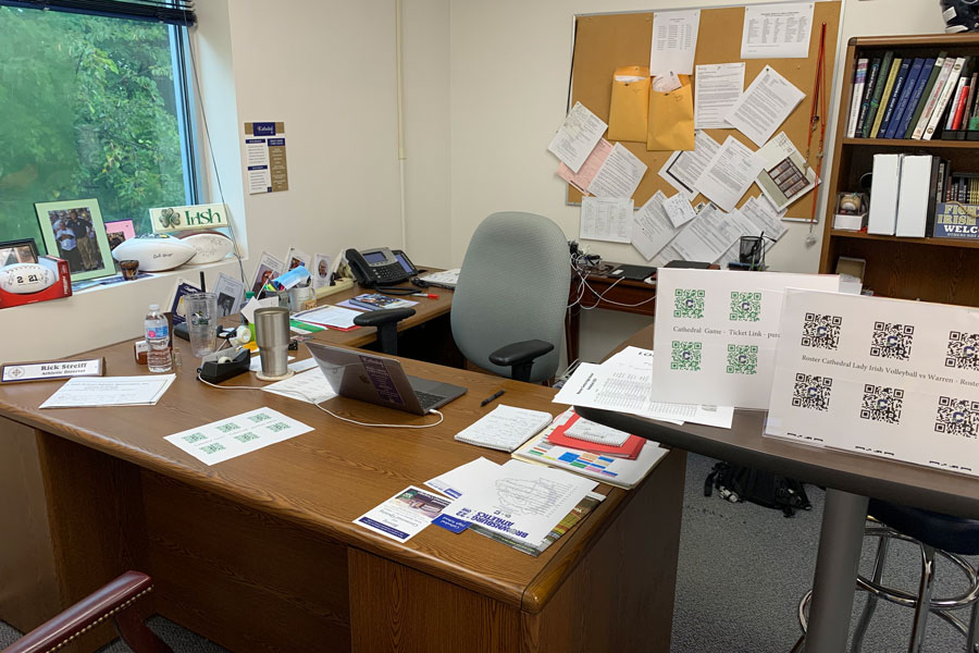 A display next to the desk of Athletics Director Mr. Rick Streiff includes a display of QR codes to access the online ticketing system. 