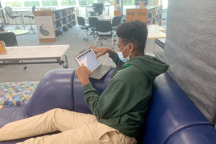 During E period on Sept. 17, a student works on his iPad in the library. 