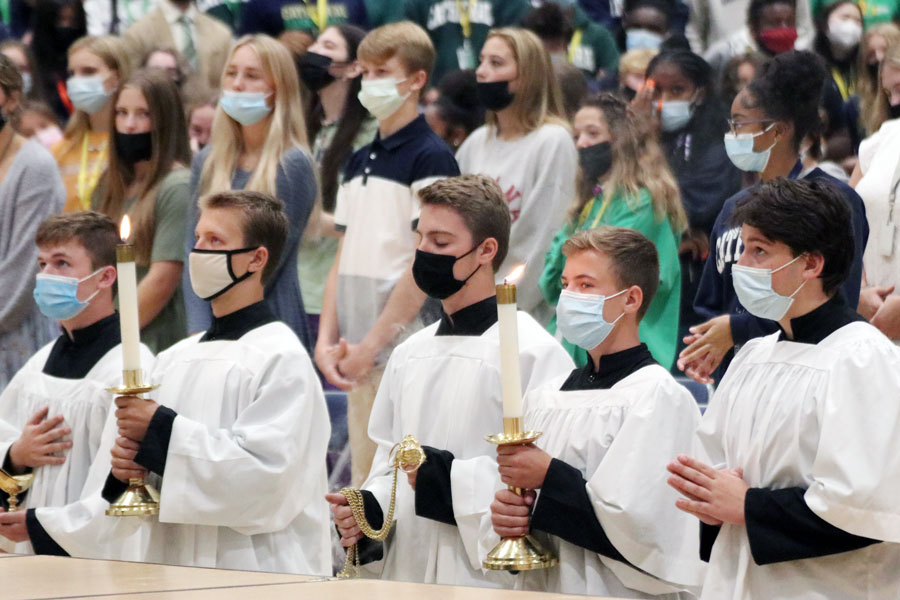 During the Sept. 15 Mass in the Welch Activity Center, servers stand before the altar. 