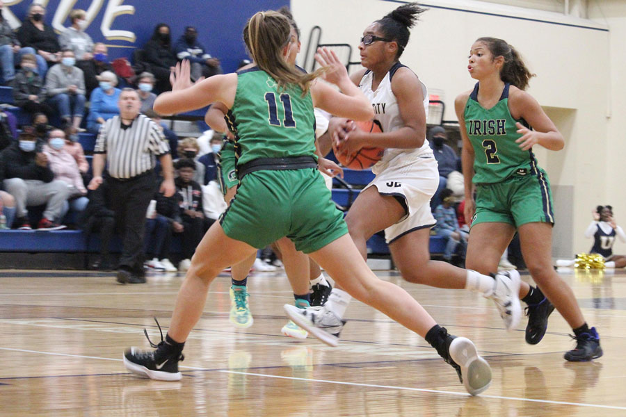 During the varsity basketball team’s 66-33 win over University on Nov. 16, junior Nya Huff (hidden behind her teammate), freshman Abby Beasley (11) and senior Gabby Gay (2) play some wicked defense.
