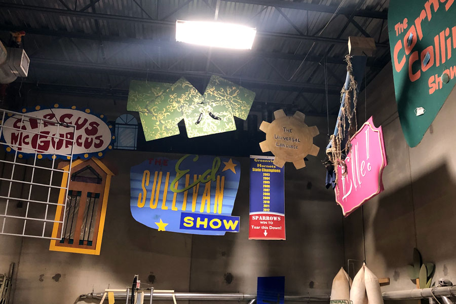 Props from previous shows hang from the ceiling in the back of the auditorium. 