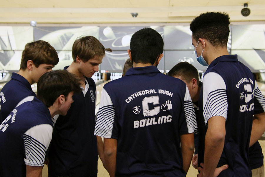 At the Expo Bowl on the Southeast side, members of the men’s bowling team huddle before the match against New Palestine, which the team won, with the Irish setting school records in team game and team series scores.