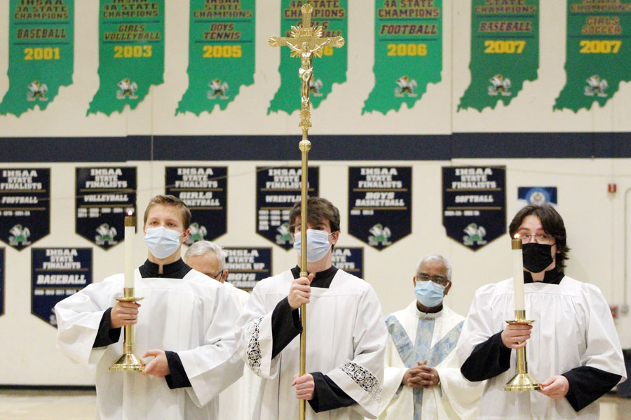 Altar servers seniors Roch Egan, Will Mayer and Quinn Gianoli participate in the procession at end of Mass on Jan. 6. 