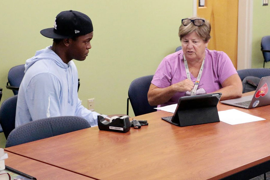 During the college admissions bootcamp in August, English teacher Ms. Laurie O’Brien reviews college application material with senior Jerron Conway. O’Brien is one of several AP teachers who are preparing their students now for the AP exams in May.