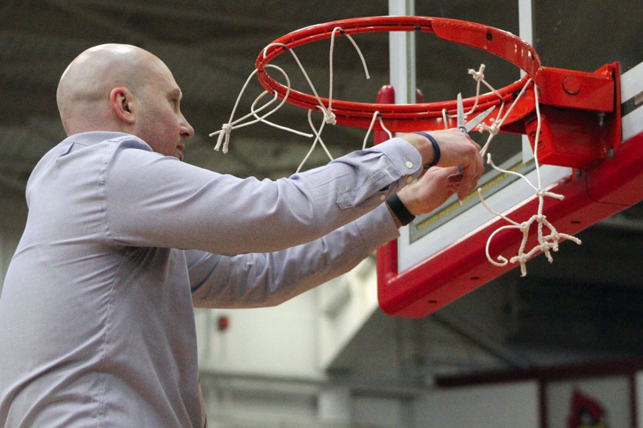 Head Coach Mr. Jason Delaney cuts down the nets at the Hatchet House in Washington after his team defeated Bloomington North in the  Semistate on March 19. 