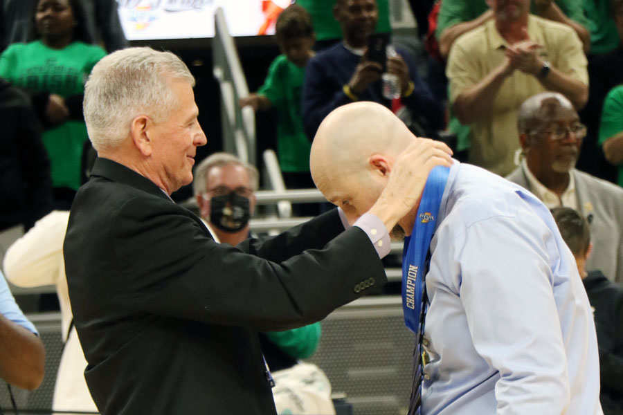 Basketball Head Coach Mr. Jason Delaney receives his Class 4A State basketball championship medal from Mr. Dave Worland. 