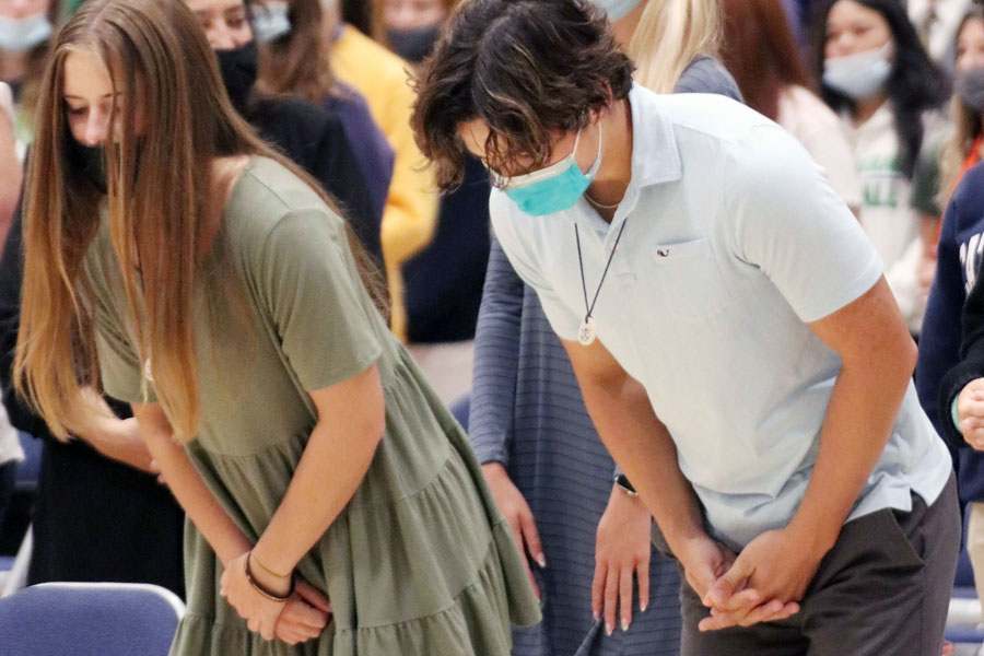 At a Mass earlier this school year, students bow before the altar. 