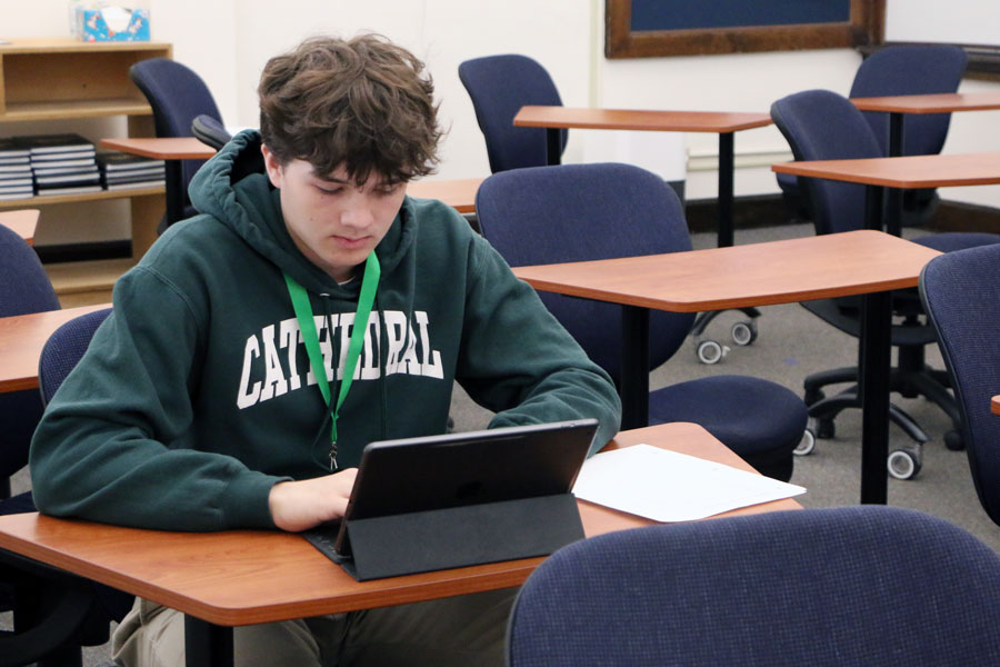 During his E period newspaper class on April 7, sophomore Luke Spencer works on his assignment for the next issue of the Megaphone.