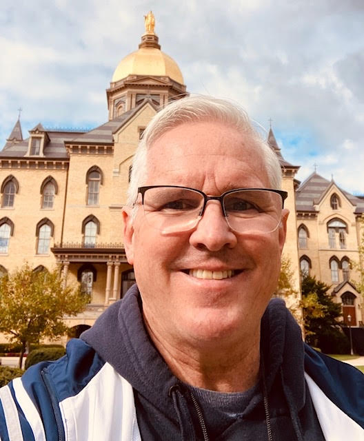 Mr. Matthews smiles for a picture in front of the Golden Dome at Notre Dame.