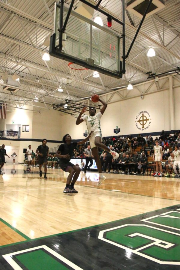 Going up for a dunk at a home game, Xavier Booker currently averages 13.5 ppg and 8.6 rebounds.