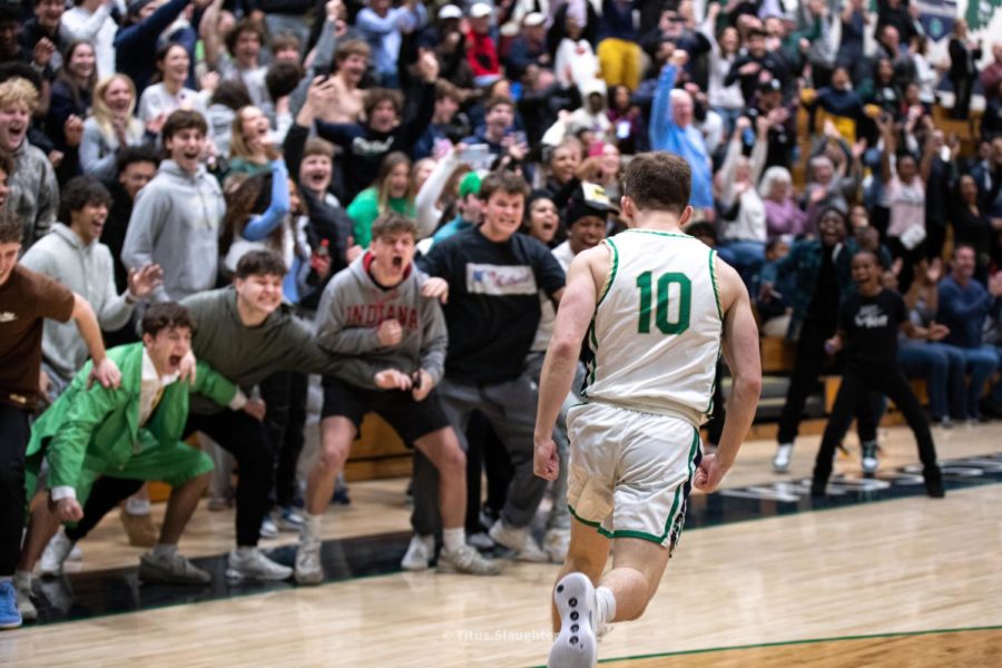 Senior and equipment manager Shaun Marbaugh celebrates with the student section after a made basket on Feb. 21 against Zionsville. The Irish defeated the Eagles 67-55.