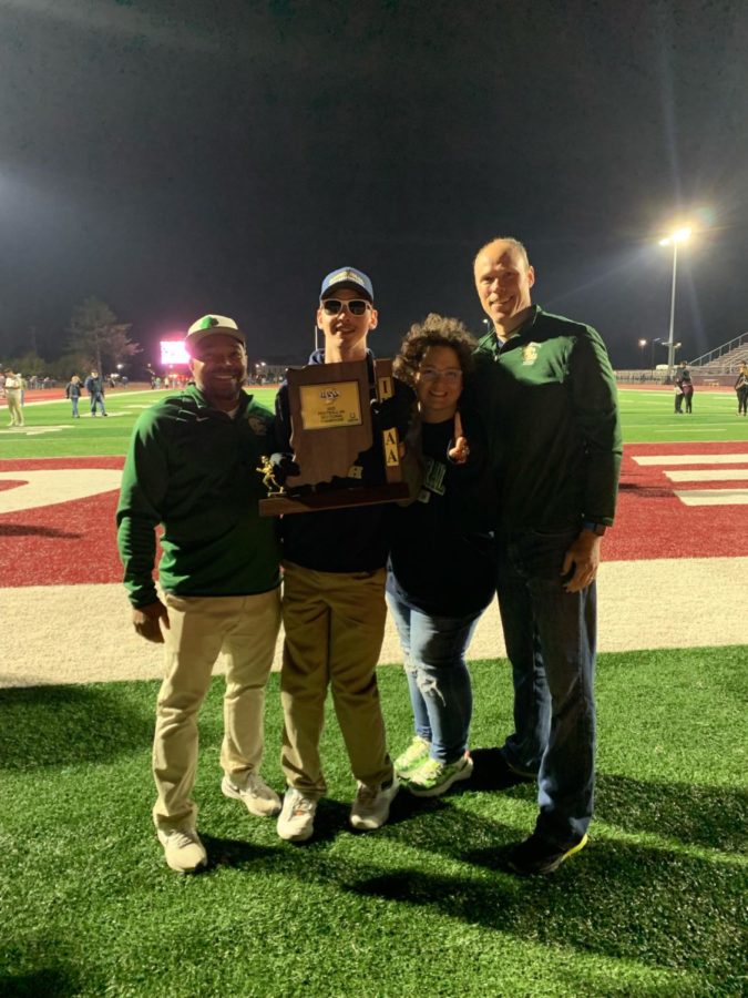 Mason holds the State Championship plaque standing with Coach Brooks and his parents.
