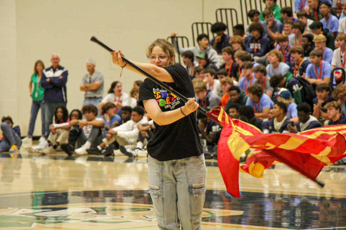 Senior Joan Darnell, a member of the Color Guard, performing a routine during the school assembly.  Color Guard at Cathedral is a friendly and welcoming group that does competitive dance based routines while adding flags and other equipment to their performance. Alexis Howard, Cathedrals new Color Guard Director said, “I have been working hard to establish CHS very own Winter Guard for the 23-24 IHSCGA season. I am so excited.”