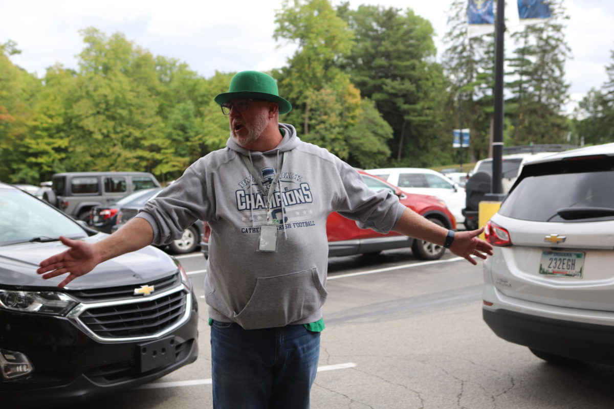 Mr. Anthony Ernst, Director of Student Activities, directs traffic sporting some Irish apparel to celebrate Homecoming Week.